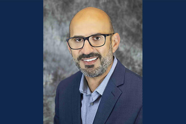 Amnar Razak, MD., headshot with blue background